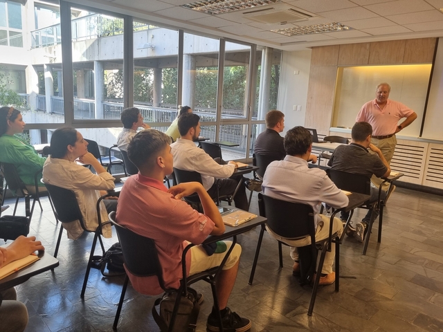 Profesor al frente de estudiantes en una sala de clases 